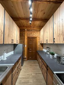 a large kitchen with wooden cabinets and a wooden door at Green District - Riverside Luxury Lodge in Banja Luka