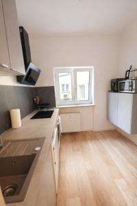 a kitchen with white cabinets and a wooden floor at Munich Premium Guesthouse in Munich +11 photos