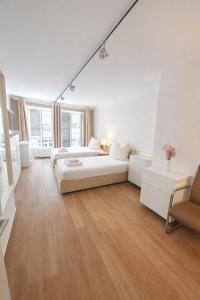 a white living room with a couch and a bed at Munich Premium Guesthouse in Munich