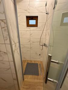 a bathroom with a shower with a glass door at Green District - Riverside Luxury Lodge in Banja Luka