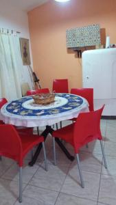 einem Tisch mit roten Stühlen und einem Teller darauf in der Unterkunft La casita in Villa Santa Cruz del Lago