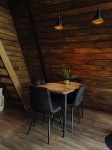 a table and chairs in a room with wooden walls at Aframe Shepit in Sosnovka