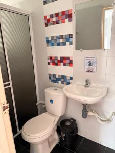 a bathroom with a toilet and a sink at Hotel Atalayas in Yopal +9 photos