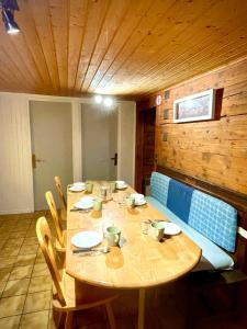 une table en bois avec des chaises et un plafond en bois dans l'établissement CHARMIEUX appartement en chalet typique, au Grand-Bornand