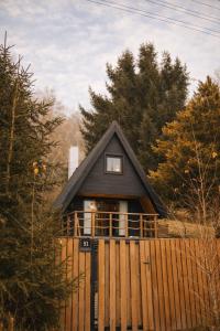 een klein huis met een hek ervoor bij The Nest - Sauna and Hot Tub in Rynoltice