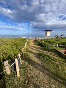 una recinzione di legno accanto a una spiaggia con l'oceano di Casa com piscina e área kids a Serra