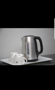 Eine Kaffeekanne steht auf einem Teller mit einem Handtuch. in der Unterkunft Hilltop apartment Ikeja in Agidingbi