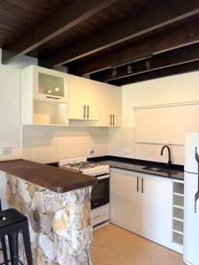a kitchen with white cabinets and a stone island at Casa Alfonsina in Chapadmalal