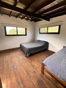 a bedroom with two beds and two windows at Casa Alfonsina in Chapadmalal