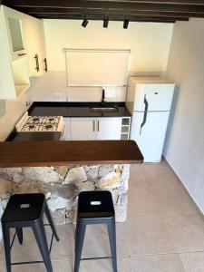 a kitchen with a counter and two stools in it at Casa Alfonsina in Chapadmalal