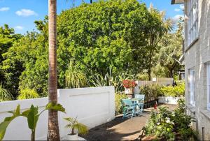 een achtertuin met een palmboom en een witte schutting bij Kowhai Apartment-Ground Floor in Pukekohe East +2 foto's