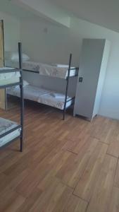 een kamer met 3 stapelbedden en een houten vloer bij Alpha vision Smestaj in Belgrado