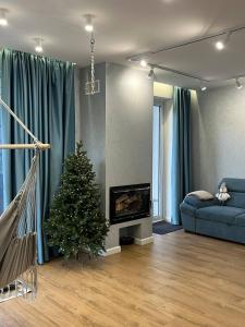ein Wohnzimmer mit einem Weihnachtsbaum und einer Couch in der Unterkunft Tatariv-hills in Tatariw