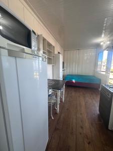 a kitchen with a refrigerator and a room with a bed at Container Porto Alvorada in Imbituba +10 photos