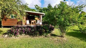 Una pequeña cabaña con una mesa y sillas en un patio. en Ti' Dola Sab gîte 4 étoiles, en Grand-Bourg