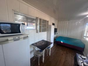 a small kitchen with a table and a microwave at Container Porto Alvorada in Imbituba