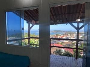 a room with a balcony with a view of a city at Container Porto Alvorada in Imbituba
