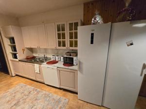 a kitchen with white cabinets and a refrigerator at Patomajat in Rovaniemi