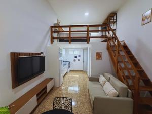 a living room with a couch and a staircase at Cataratas Loft Residence in Foz do Iguaçu