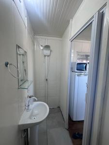 a small bathroom with a sink and a microwave at Container Porto Alvorada in Imbituba