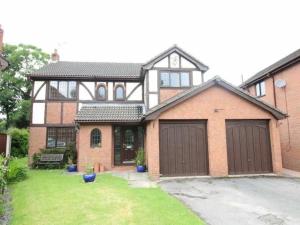 een groot bakstenen huis met twee garagedeuren bij Rode house home stay in Rode Heath