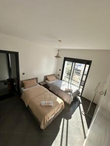 twee bedden in een kamer met een raam bij Maroc Stay in Imsouane
