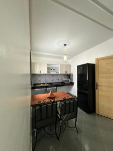 een keuken met een tafel en een zwarte koelkast bij Maroc Stay in Imsouane