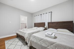 two beds in a bedroom with white walls at 3 BR • Full Kitchen • Sleeps 8 in Jersey City