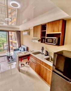 een kleine keuken met een spoelbak en een magnetron bij Bright Sun Apartment with Pools in Rawai Beach