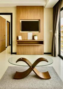 een woonkamer met een flatscreen-tv en een groot bronzen beeld bij Bright Sun Apartment with Pools in Rawai Beach
