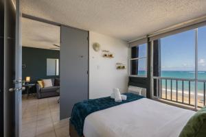 una camera da letto con un letto e vista sull'oceano di Punta Arenas 1BDR Oceanfront Pool Parking a San Juan Altre 28 foto