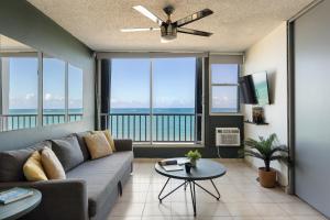 un soggiorno con un divano e un tavolo di Punta Arenas 1BDR Oceanfront Pool Parking a San Juan