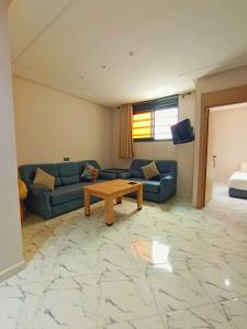 a living room with a couch and a table at Blue Wave Surf House in Mirleft