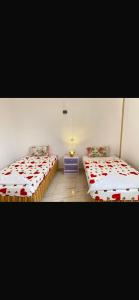 a room with two beds and a nightstand between them at Hadi Guest House in Luxor