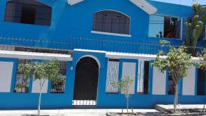 un edificio azul con árboles delante de él en Ramirez House en Arequipa