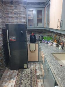 een keuken met een grote zwarte koelkast. bij Apartment Alexandria City Center in Alexandrië +10 foto's