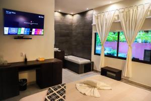 een badkamer met een tv aan de muur bij Hotel Diosa del Agua Bacalar in Bacalar