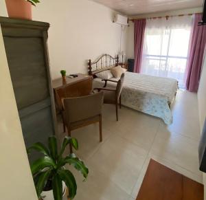 ein Schlafzimmer mit einem Bett, einem Schreibtisch und einem Stuhl in der Unterkunft La brisa in San Antonio de Areco