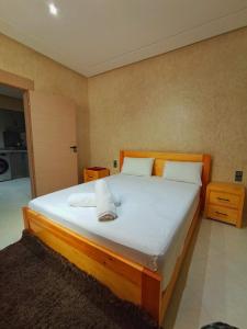 a bedroom with a large bed with white sheets and pillows at Blue Wave Surf House in Mirleft