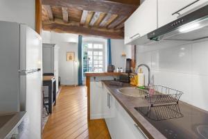 a kitchen with a sink and a refrigerator at cœur du Bouffay in Nantes