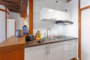 een keuken met witte kasten en een spoelbak bij cœur du Bouffay in Nantes