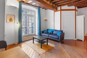 een woonkamer met een bank en een tafel bij cœur du Bouffay in Nantes