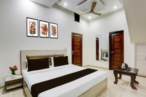 a bedroom with a large bed and a telephone at Hotel O Lohgarh Road Zirakpur Formerly JB Plaza in Zirakpur