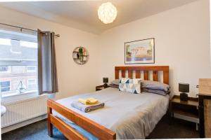 una camera da letto con un letto e una finestra di Colchester CntrCosyOfficePatioTrainParkPet a Colchester