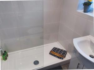 un bagno bianco con doccia e lavandino di Colchester CntrCosyOfficePatioTrainParkPet a Colchester Altre 22 foto