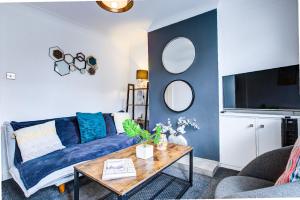 un soggiorno con un divano blu e un tavolo di Colchester CntrCosyOfficePatioTrainParkPet a Colchester