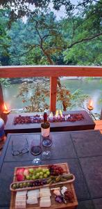 een tafel met wijnglazen en groenten op een balkon bij Cliffside Cabin at Piney Falls - with Creek Access  +52 foto's