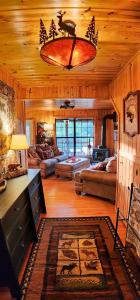 een woonkamer met een kroonluchter in een hut bij Cliffside Cabin at Piney Falls - with Creek Access 