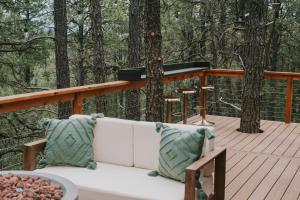 a white couch sitting on a wooden deck with trees at A-frame 10 Min to Downtown Durango in Durango