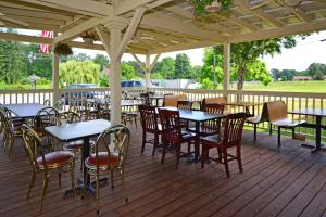 a patio with tables and chairs on a deck at Howard Johnson by Wyndham Saugerties in Saugerties